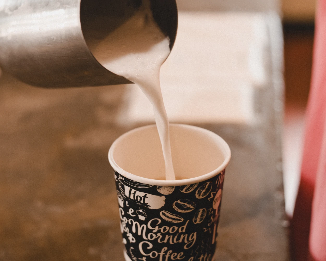 Frothed milk being poured into a cup